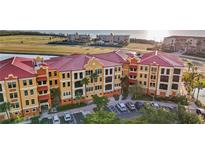 Aerial view of condos with red roofs, palm trees and parking lot at 95 Vivante Blvd # 9524, Punta Gorda, FL 33950