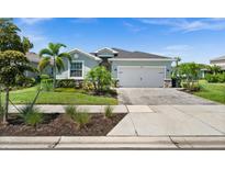Charming single-story home with well-manicured lawn, lovely landscaping, and a paved driveway leading to a two-car garage at 17459 Palmetto Pass Ln, Punta Gorda, FL 33982