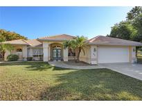 Charming single-story home with a tile roof, lush landscaping, and an attached two-car garage at 1856 Nuremberg Blvd, Punta Gorda, FL 33983