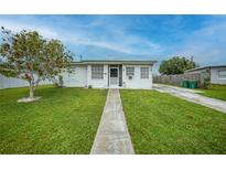 Charming single-story home with a well-manicured lawn and a quaint walkway leading to the entrance at 2321 Dallas St, Port Charlotte, FL 33952