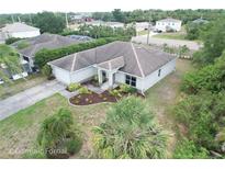 An aerial view of a well maintained single story home with mature landscaping, a long driveway, and an attached garage at 2857 Brewster Rd, North Port, FL 34288
