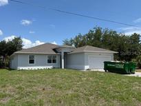 Charming single-story home features a well-maintained lawn and a two-car garage at 384 Prineville St, Port Charlotte, FL 33954