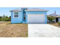 Charming light blue single-Gathering home featuring a two-car garage and manicured lawn at 4285 Oak Terrace Cir, Port Charlotte, FL 33953