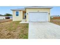 Charming single-Gathering home featuring a large two-car garage and well-maintained front lawn at 4290 Oak Terrace Cir, Port Charlotte, FL 33953