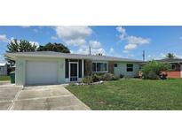 Charming single-story home with a well-maintained lawn, stone accents, and attached garage at 570 Mimosa Nw Ave, Port Charlotte, FL 33952