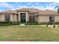 Inviting home with a well-maintained lawn, lush landscaping and a beautiful red tile roof at 857 Macaw Cir, Venice, FL 34285