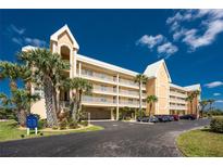 Multi-level condominium with balconies, palm trees, and ample parking on a sunny day at 101 N Marion Ct # 215, Punta Gorda, FL 33950