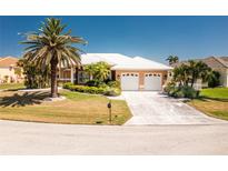 Charming single-story home with a well-manicured lawn, lovely landscaping, and a two-car garage at 1374 Grebe Dr, Punta Gorda, FL 33950