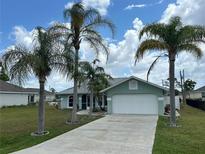 Charming single-story home with a well-manicured lawn and swaying palm trees at 16072 Galiano Ct, Punta Gorda, FL 33955