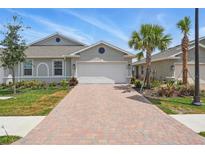 Charming one-story home featuring a brick driveway, attached garage, and well-maintained landscaping at 16079 Bandermill Dr, Port Charlotte, FL 33953