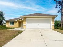 Charming single-story home featuring a two-car garage, well-manicured lawn, and a welcoming entrance at 2336 Redfern St, Port Charlotte, FL 33948