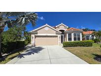 Charming single-story home featuring a tile roof, well-manicured landscaping, and a two-car garage at 26073 Feathersound Dr, Punta Gorda, FL 33955