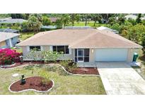 Charming single Gathering home with a well maintained lawn, lovely landscaping, and an attached two car garage at 3080 Saint James St, Port Charlotte, FL 33952