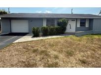 Charming single-story home features a well-manicured lawn, attached garage, and inviting front entrance at 635 W Tarpon Nw Blvd, Port Charlotte, FL 33952