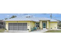 Charming single-story home with a metal roof, screened garage, and a cozy front porch at 7333 Watson Ln, Port Charlotte, FL 33981