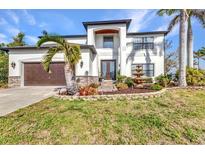 Stunning two-story home with a well-manicured lawn, fountain, and lush landscaping at 9239 Impala Cir, Port Charlotte, FL 33981