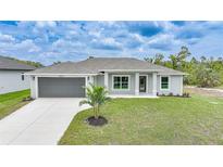 Charming single-story home with a well-manicured lawn, gray exterior, and a two-car garage at 13972 Chesswood Ln, Port Charlotte, FL 33981