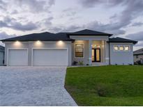 Beautiful single-story home featuring a three-car garage, landscaped yard, and neutral color scheme at 15504 Melport Cir, Port Charlotte, FL 33981