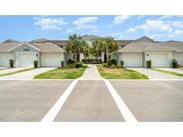Inviting condo exterior features palm trees, well-manicured lawns, and convenient attached two-car garages at 15990 Grassland Ln # 3024, Punta Gorda, FL 33982