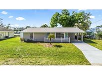 Charming single-story home with a well-maintained lawn, mature trees, and a welcoming front entrance at 2331 Cannolot Blvd, Port Charlotte, FL 33948