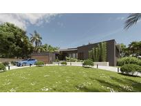 Stunning exterior elevation with a modern design, lush landscaping, and a charming blue car parked nearby at 2523 Ryan Blvd, Punta Gorda, FL 33950