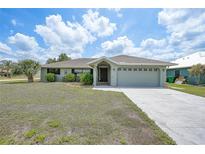 Charming single-story home with a well-maintained lawn and attached two-car garage at 26103 Salonika Ln, Punta Gorda, FL 33983