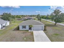 Charming single-story home featuring a well-manicured lawn and attached two-car garage in a quiet neighborhood at 27306 Deep Creek Blvd, Punta Gorda, FL 33983