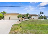 Charming single-story home featuring a spacious three-car garage, lush lawn, and inviting curb appeal at 2911 Riverside Dr, Punta Gorda, FL 33950