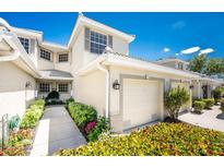 Inviting two-story townhome features a private garage and beautifully landscaped walkway at 3412 Grand Vista Ct # 202, Port Charlotte, FL 33953