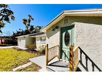 Charming single-story home featuring a light green front door with an oval window, complimented by lush front yard at 3502 N Lincoln Ave, Tampa, FL 33607