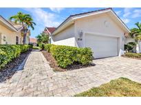 Beautiful home showcasing a brick driveway, lush greenery, and attached garage at 3715 Albacete Cir # 93, Punta Gorda, FL 33950