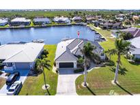 Aerial view of waterfront property with lush landscaping, boat dock, and tile roof at 3907 San Pietro Ct, Punta Gorda, FL 33950
