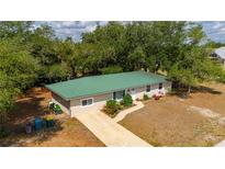 Charming single-story home with a well-manicured lawn and a green metal roof at 4009 Yucatan Cir, Port Charlotte, FL 33948