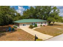 Beautifully landscaped single-story home with a lush green metal roof at 4009 Yucatan Cir, Port Charlotte, FL 33948