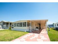 Inviting single-story home with a covered carport and screened porch at 643 Blackburn Blvd, North Port, FL 34287