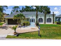 Charming single-story home with a well-manicured lawn, lush landscaping, and an attached two-car garage at 22498 Westchester Blvd, Punta Gorda, FL 33980