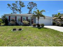 Charming single-story home with a well-manicured lawn and colorful landscaping at 25324 Aysen Dr, Punta Gorda, FL 33983