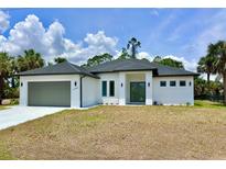 This home has a 2 car garage and a manicured lawn at 2743 Begonia Ter, North Port, FL 34286