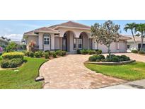 Lovely single-story home features a barrel tile roof, arched entryway, and paver driveway with lush landscaping at 2833 La Mancha Ct, Punta Gorda, FL 33950