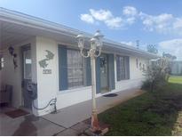 Charming single-story home with blue shutters, manicured lawn, and decorative fish accents at 330 Lasayette Ne Dr, Port Charlotte, FL 33952