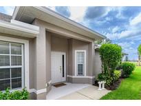 Inviting front entrance with well-maintained landscaping and neutral exterior paint color at 3702 Lakewood Blvd, North Port, FL 34287
