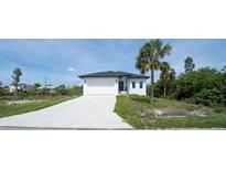 Beautiful single-story home featuring a pristine white exterior and a spacious driveway at 3920 Wisteria Pl, Punta Gorda, FL 33950