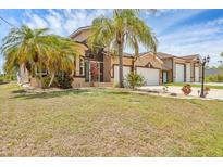 Inviting two-story home with a lush lawn and mature palm trees, offering curb appeal and Florida charm at 8183 Deland St, Port Charlotte, FL 33981