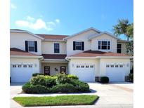 Inviting exterior of a bright and sunny two-story townhome with attached garages and manicured landscaping at 1271 Jonah Dr, North Port, FL 34289