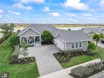 Stunning lakefront home featuring a spacious layout, elegant gray exterior, and lush landscaping at 17213 Bullhorn Cir, Punta Gorda, FL 33982