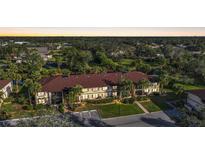 Inviting condo building surrounded by lush greenery and palm trees at 19505 Quesada Ave # M104, Port Charlotte, FL 33948