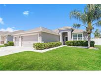 Charming single-story home with a well-manicured lawn, inviting entrance, and attached two car garage at 20067 Oakflower Ave, Tampa, FL 33647