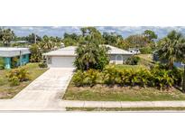 Charming single-story home featuring a well-maintained lawn and mature palm trees at 2008 Pellam Blvd, Port Charlotte, FL 33948