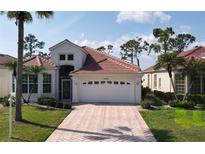Charming single-story home featuring a well-manicured lawn and a brick driveway leading to a two-car garage at 26089 Seminole Lakes Blvd, Punta Gorda, FL 33955