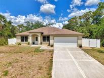 Charming single-story home featuring a well-manicured lawn, neutral paint, and an attached two-car garage at 3021 Toluca Ter, North Port, FL 34286